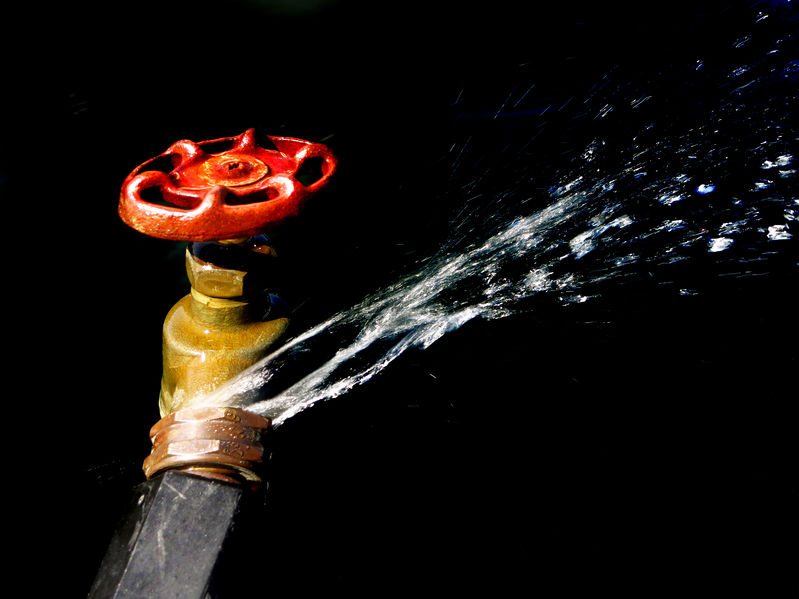 Detail of hose faucet connection leaking and squirting water spray